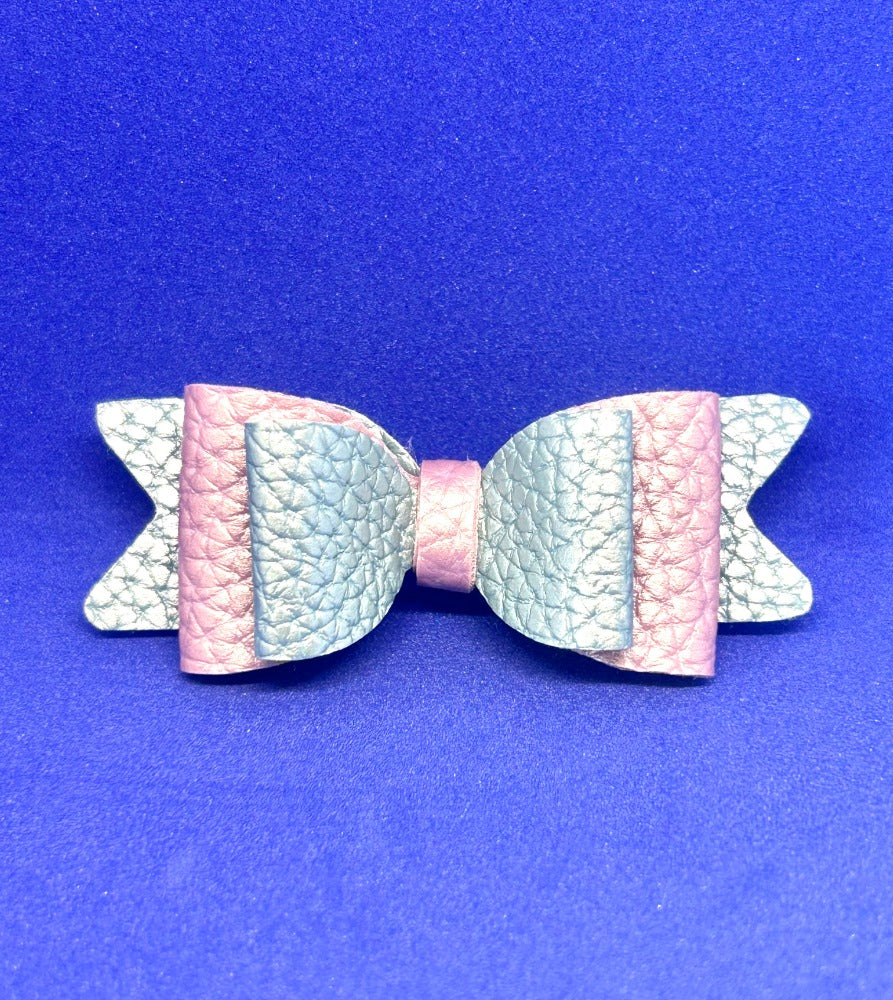 Pastel-colored bow-shaped hair clip on a blue background