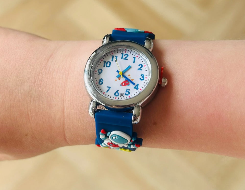 Children's watch with a blue strap featuring cartoon characters on a wrist.