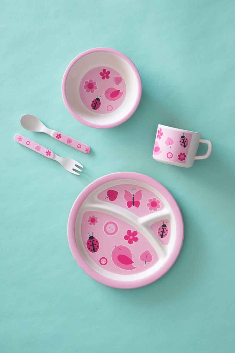 Pink children's dining set with bowl, cup, and fork on a teal background