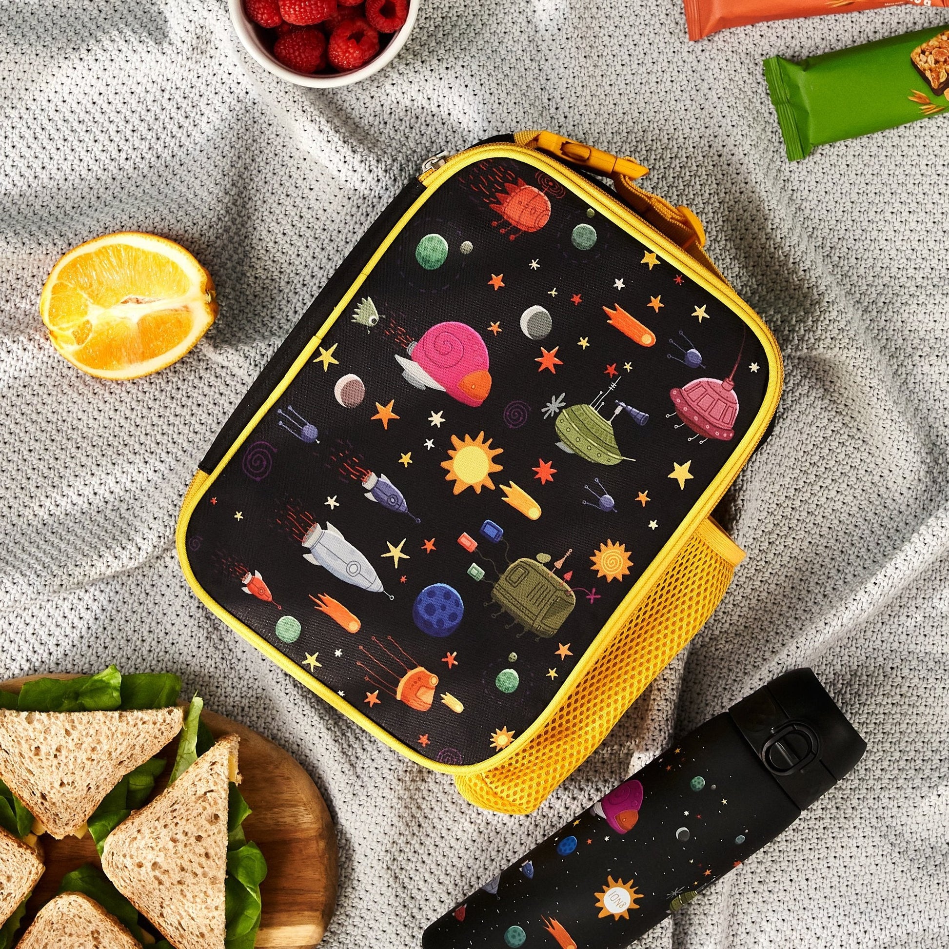 SCHOOL LUNCH BAG WITH SPACE THEMED DESIGN ON A GREY CLOTH BACKGROUND