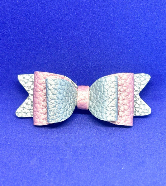 Pastel-colored bow-shaped hair clip on a blue background
