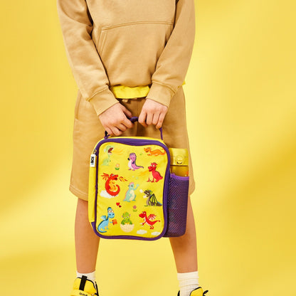 Person holding a colorful lunch bag with cartoon designs on a yellow background