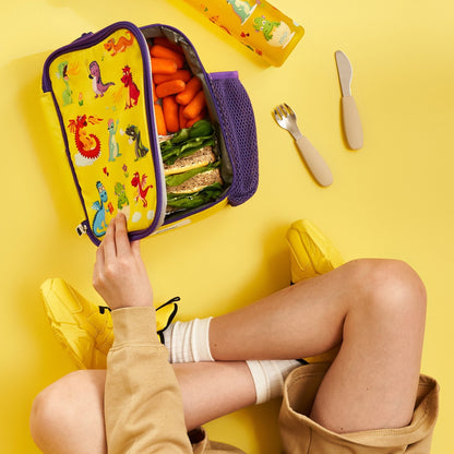 Person opening a colorful lunchbox with snacks on a yellow background