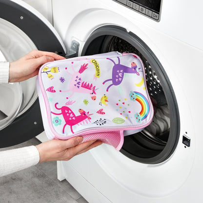 Person holding a colorful unicorn-patterned pouch in front of an open washing machine.