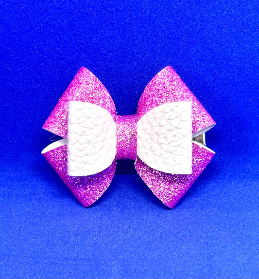 Pink glittery bow with white center on a blue background