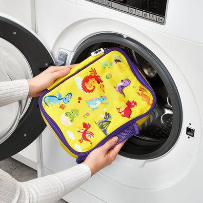 Person holding a colorful pot holder with cartoon designs in front of an open washing machine.